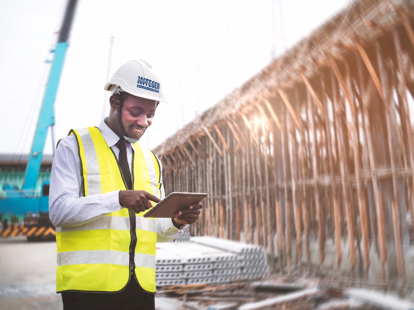 Engineer checking drawings on a tablet beside a rebar cage
